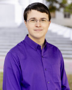 Headshot of David Morgens in front of blurred stair background